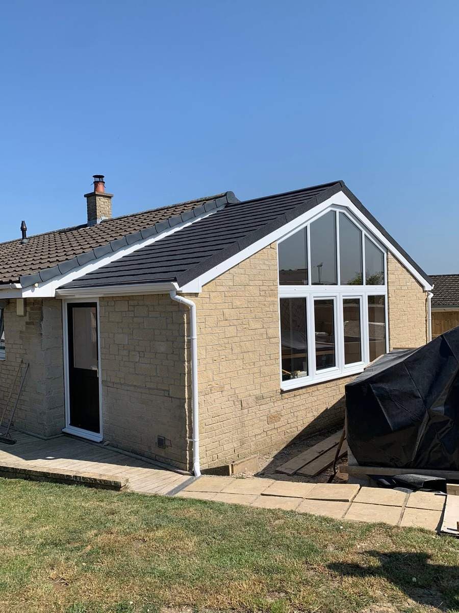 The new stone gable built up, with apex glazing and the new tiled roof on