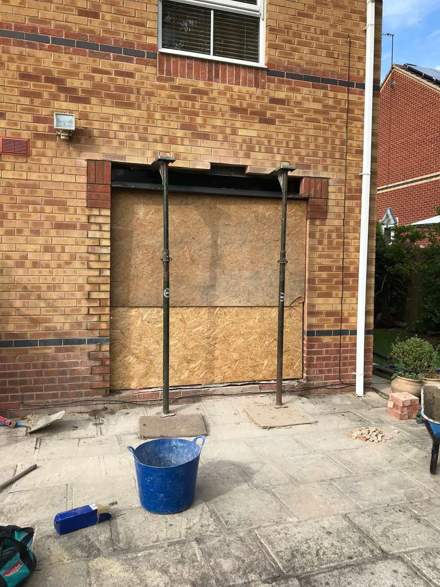 A boarded opening at the back of a house, ready for the new doors